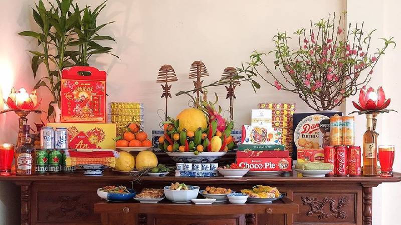 Bàn thờ Thần Tài - Ông Địa được trang trí đầy đủ lễ vật, chuẩn bị cho nghi thức cúng thần linh mùng 1 Tết.