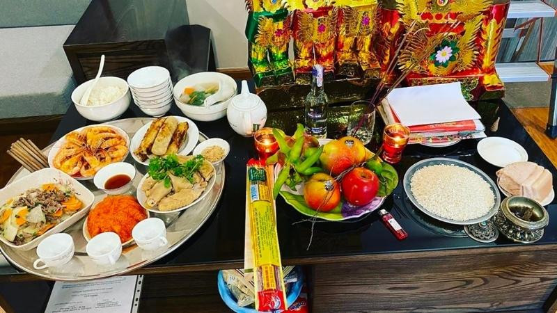 Mâm lễ vật đơn giản với hoa quả, chè ngọt, nước và rượu để cúng Thần Bếp hàng ngày