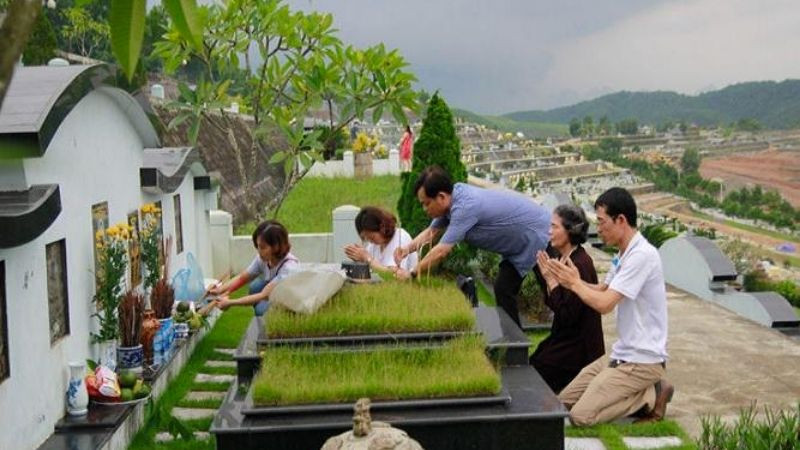 Người thân đang dọn dẹp, chăm sóc mộ phần trong ngày tảo mộ cuối năm