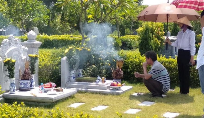 Người thân quây quần bên mộ tổ tiên để văn khấn xin gia tiên phù hộ công việc và cầu an