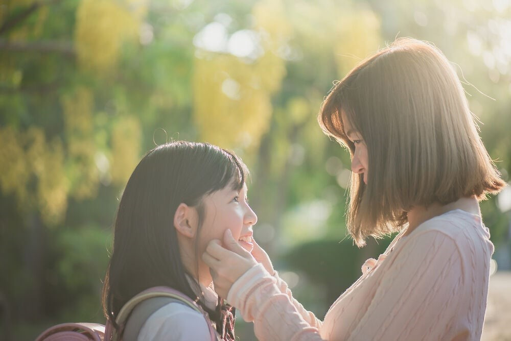 Alt text: Người cha và con gái đang ngồi nói chuyện thân mật trong phòng khách, người cha lắng nghe con gái một cách chăm chú và nhẹ nhàng, thể hiện sự giao tiếp hiệu quả.
