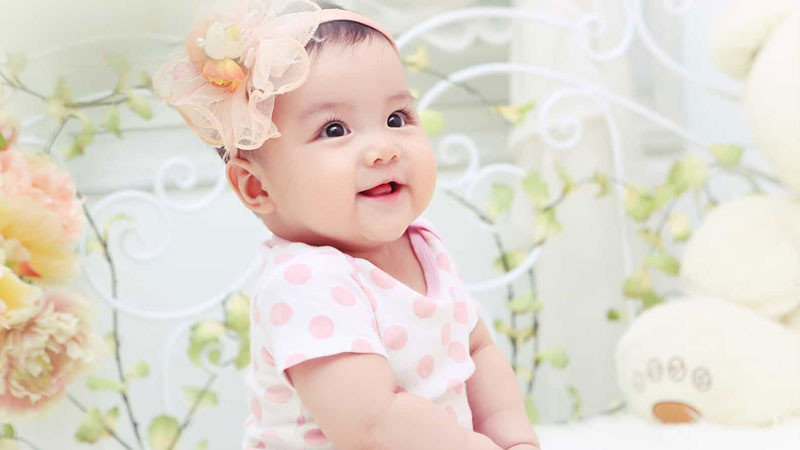 Bàn tay cầm bút ghi chép trong sổ, tượng trưng cho việc đặt tên và lên kế hoạch cho tương lai