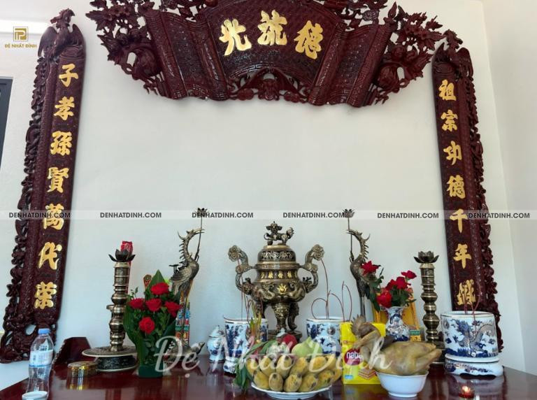 Bàn thờ gia tiên trang nghiêm với bát hương, hoa quả và đèn thờ.