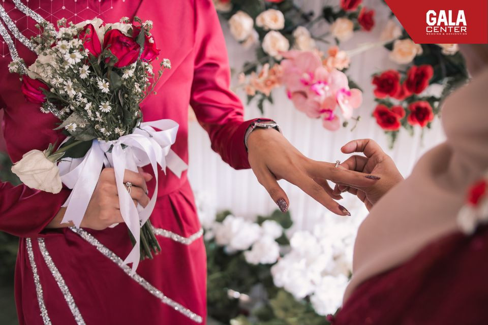 Cặp đôi đang trao nhẫn đính hôn, giải đáp thắc mắc về việc đính hôn khi gặp hạn xấu trong năm cưới 2026