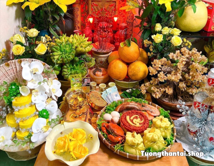 Gia chủ chuẩn bị mâm cúng Thần Tài với hoa tươi và các lễ vật truyền thống