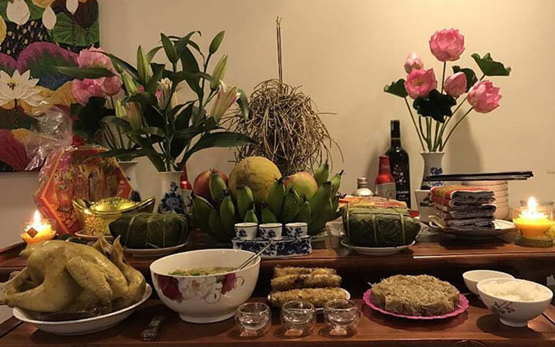 Người phụ nữ thực hiện lễ cúng tạ đất cuối năm tại ban thờ, thắp hương cầu nguyện