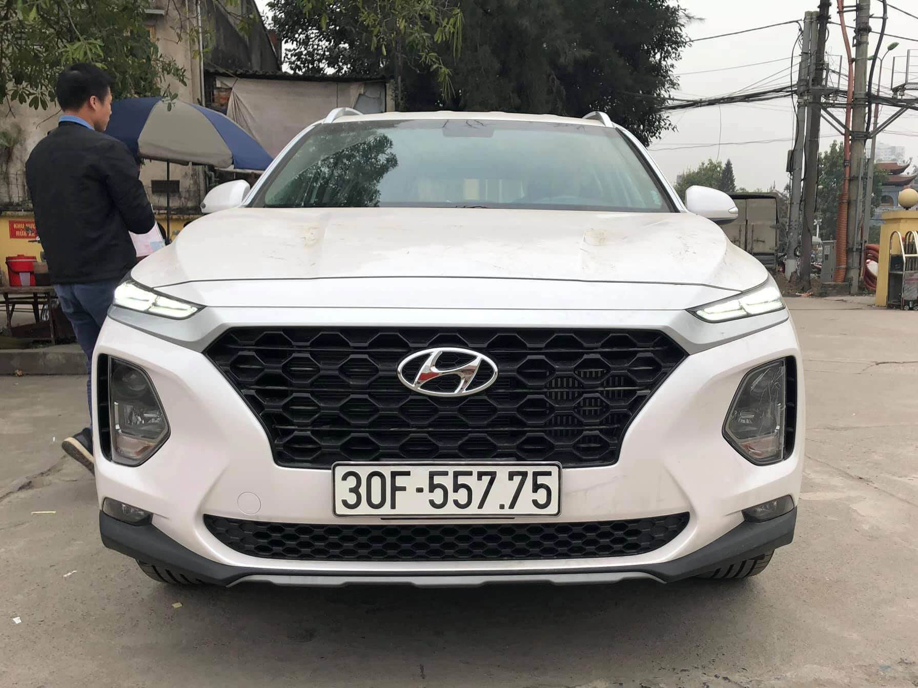 Bàn tay đang cầm máy tính, thể hiện quá trình tính toán để chọn biển số xe ô tô hợp tử vi và phong thủy.
