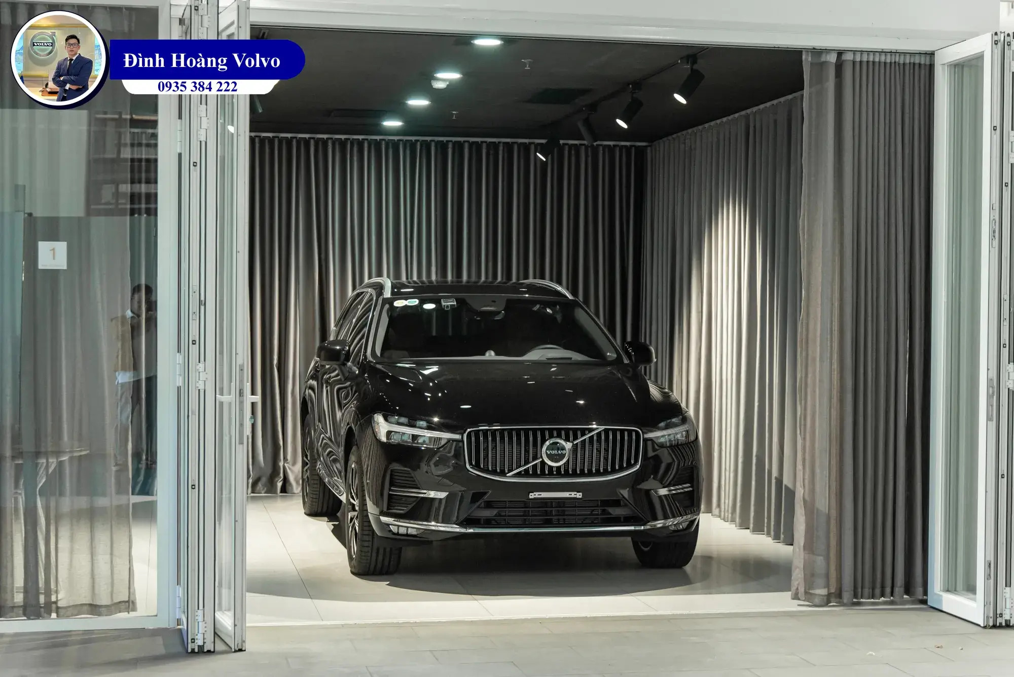Chiếc xe hơi màu xanh đậm đậu trong một showroom sang trọng, thể hiện vẻ đẹp mạnh mẽ và hiện đại.