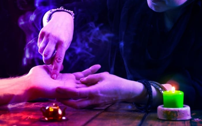Chuyên gia đang xem chỉ tay cho khách hàng