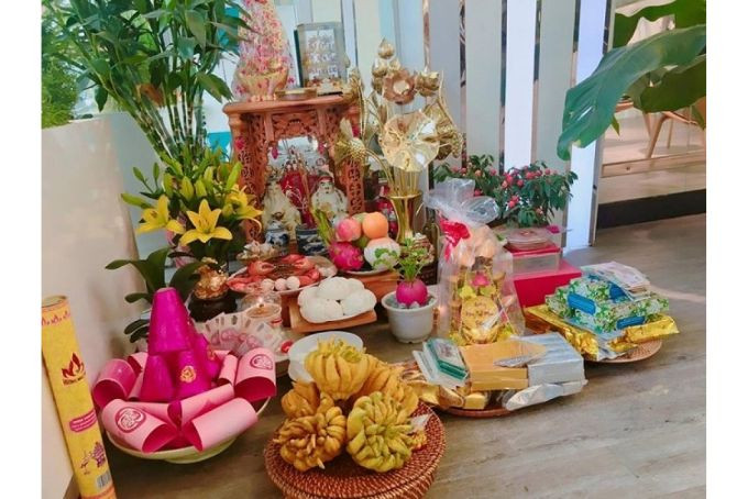 Một người phụ nữ đang lau dọn tỉ mỉ bàn thờ Thần Tài