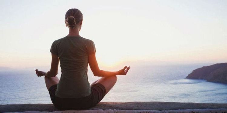 Một người phụ nữ đang ngồi thiền định tại nhà, thể hiện sự tĩnh tâm, phù hợp với câu hỏi ngồi thiền giờ nào tốt nhất