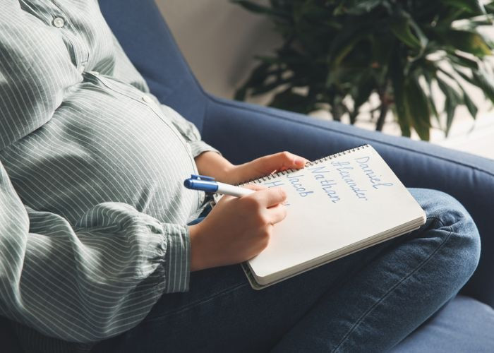 Người phụ nữ bế em bé với phong cảnh thiên nhiên tươi đẹp, tượng trưng cho ý nghĩa đặt tên con theo phong thủy hợp tuổi bố mẹ